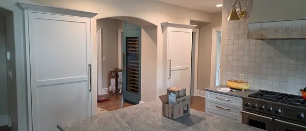Built-in refrigeration framed by white cabinetry.