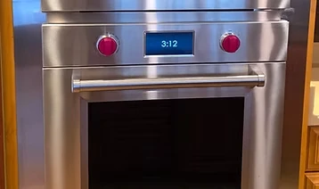 Stainless steel wall ovens framed by custom cabinetry.