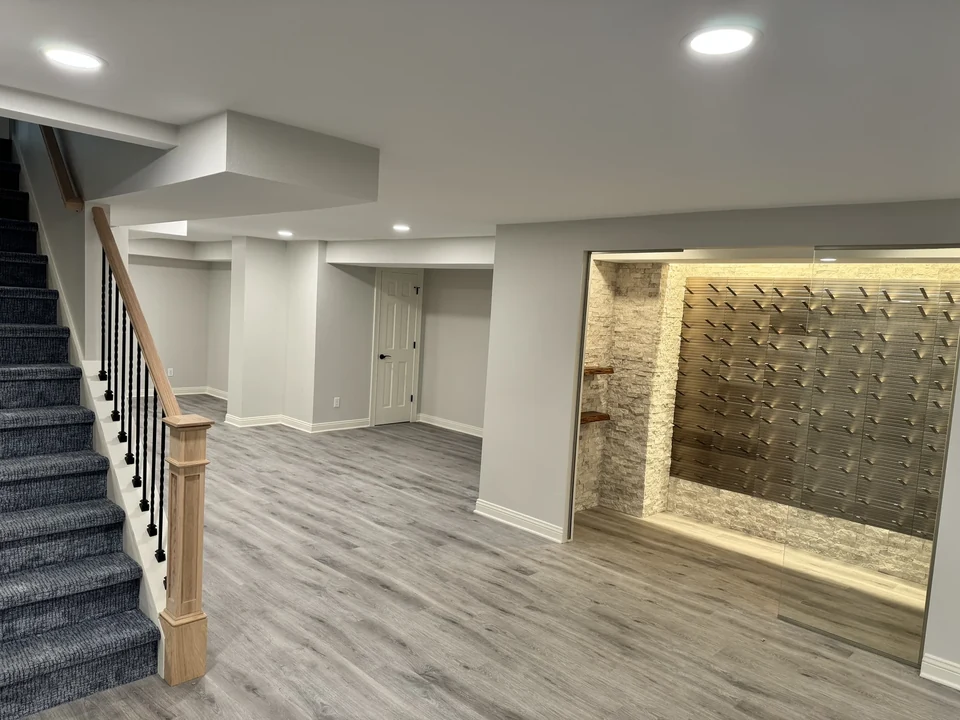 Finished lower level with a wine display and staircase