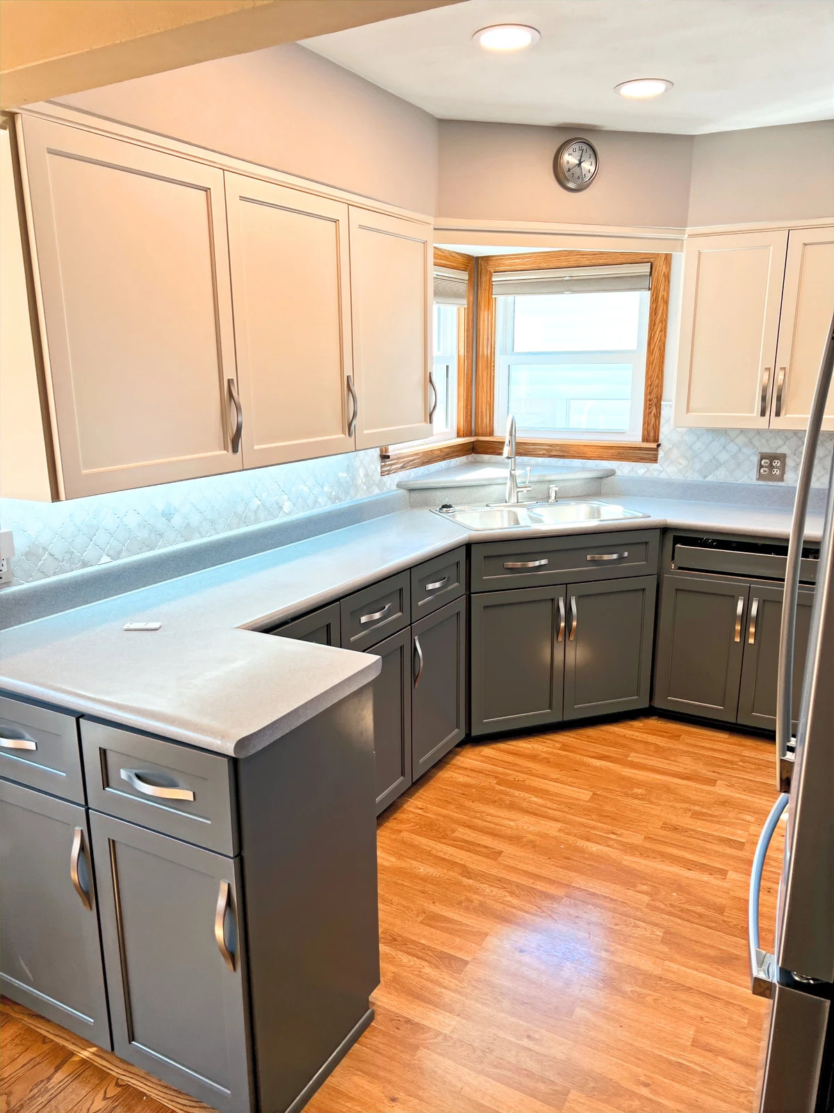 A refreshed West Allis home with light upper cabinets, gray lower cabinets, and wood floors